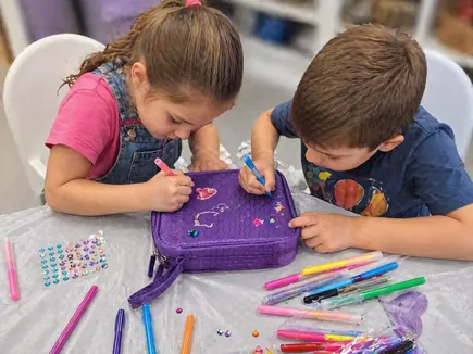 Niños personalizando la playera de un peluche